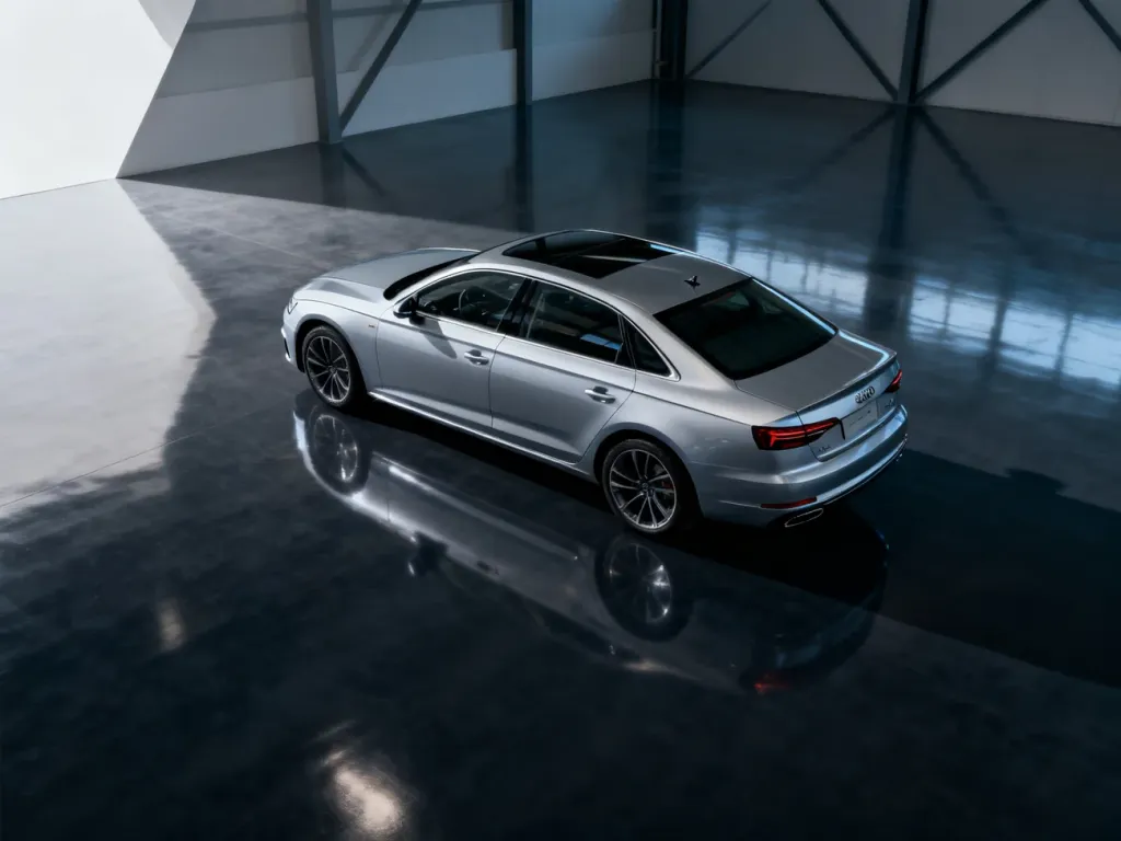 Srebrny sedan marki Skoda zaparkowany w nowoczesnym studiu na błyszczącym podłożu, podkreślającym jego aerodynamiczną sylwetkę.